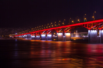 Fototapeta na wymiar background bridge with illuminated river, at night