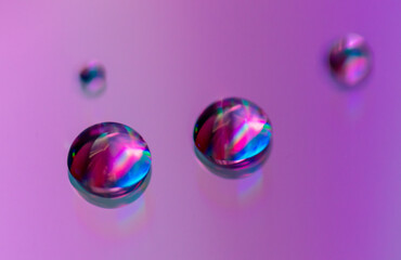 Blue drops of water on a pink background.