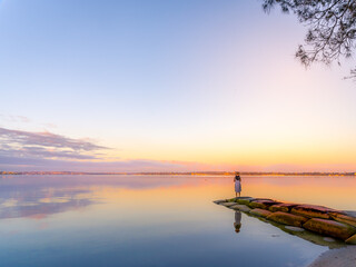 A girl in calm water river like Uyuni in the morning glow 