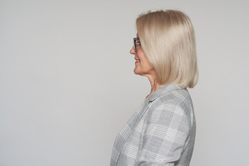 Profile portrait of an old business woman is smiling © spaxiax