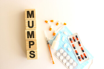 The word MUMPS is made of wooden cubes on a white background. Medical concept.