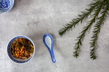 Two bowls and spoons with rice with natto  soybeans and another bowl with soy sauce. Flat lay view....