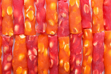 Natural fruit dessert with nuts and condensed fruit juice. Solid background with colorful sliced...