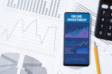 Online investment. Smartphone with a mobile app on the background of graphs and charts. Copy space