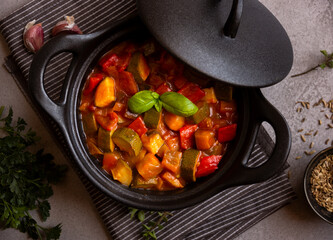 Cooked various chopped vegetables with herbs in a black cooking pot