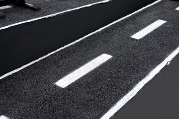 Black asphalt road with white dividing lines.Traffic lines on the street.        