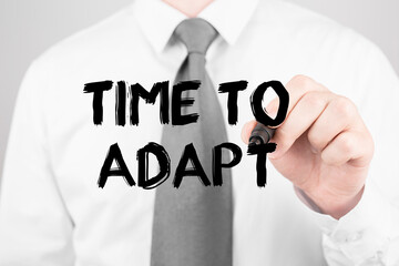 Businessman writing word TIME TO ADAPT with marker, Business concept