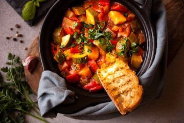 Cooked various chopped vegetables with herbs in a black cooking pot