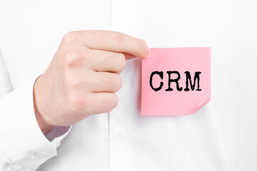 Man attaches a red sticker with text CRM overlay to his white shirt