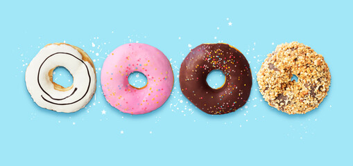 Flying delicious donuts with sprinkel on blue background with copy space