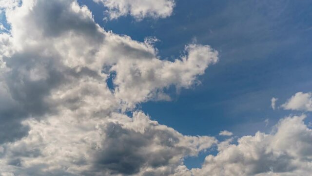 4K uhd sky timelapse with strange white and grey clouds formations in blue sky