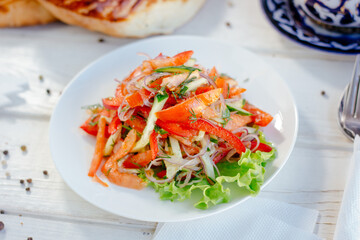 Vegetable salad on the white plate. Achik Chukchuk salad with tomatoes and onion.
