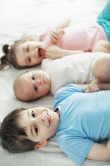 Obraz na płótnie Canvas Children lie on the bed next to the newborn baby, little sister.
