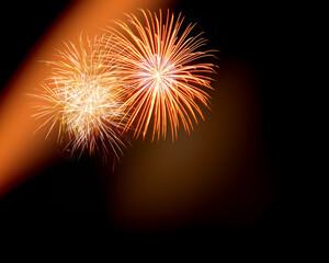 Fototapeta premium Festive colorful real fireworks elements in the night sky. Christmas holidays background with copy space for your text