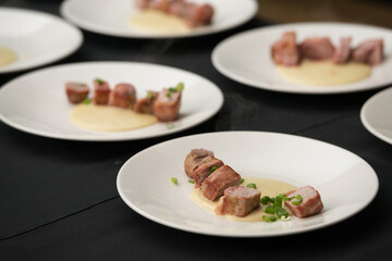 Closeup of chief serving delicious roasted pork meat wrapped in bacon. Irish traditional dish wrapped pork loin with roasted garlic