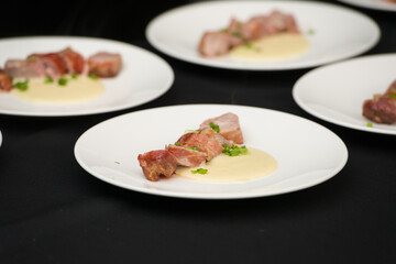 Closeup of chief serving delicious roasted pork meat wrapped in bacon. Irish traditional dish wrapped pork loin with roasted garlic