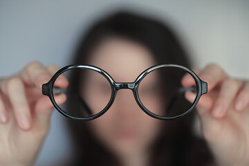 The concept of poor vision. Hold a contact lens and glasses in hand. A poster for advertising...