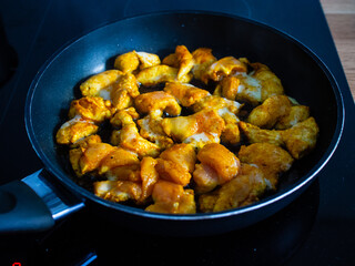 Chicken breast nuggets frying in pan
