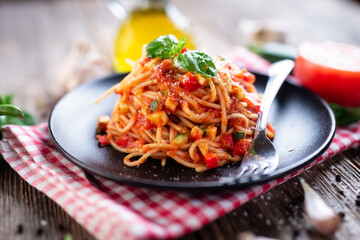 Spaghetti with eggplant, zucchini, paprika and tomato sauce - 392422420