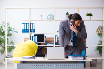 Young male employee looking after newborn at workplace