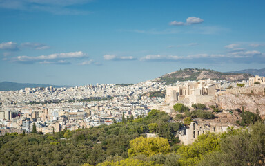 View of the city in Athens with the Propylaea in the distance against the blue sky
