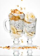 Chia pudding with banana and granola on white plate