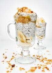 Chia pudding with banana and granola on white plate