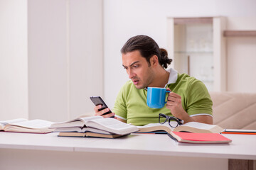 Young male student preparing for exams at home