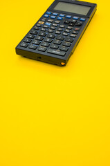 Vertical shot of a calculator on a yellow background