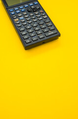 Vertical shot of a calculator on a yellow background