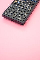 Vertical shot of a calculator on a pink background