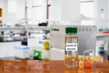 single bottle vial of Covid-19 coronavirus vaccine and syringe with medical research lab in background. 3D illustration.