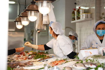 Working portrait of a fishmonger with workers