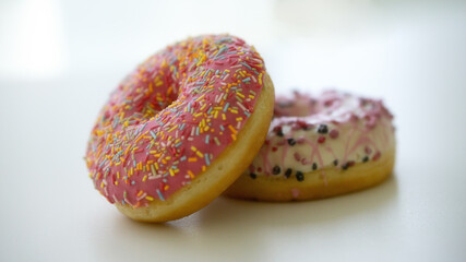 Close up of two delicious sweet tasty colorful donuts glazed and sprinkles isolated on white background