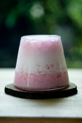 Pink blended milk beverage that is put in a small clear glass