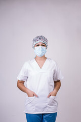 vertical portrait of a female nurse dressed in a white cascade, a mask and an operating room cap