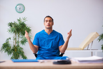 Young male doctor being extremely tired after night shift