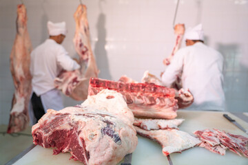 Team work butcher cut raw meats hanging in the cold store. Cattles cut and hanged on hook in slaughterhouse, Meat industry,  Wagyu Beef