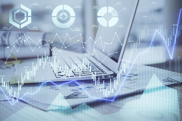 Stock market graph on background with desk and personal computer. Double exposure. Concept of financial analysis.