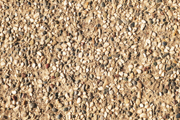 A floor of small sea pebbles on the sand as a background