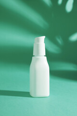 White ceramic opaque bottle on a bright green background without labels on natural background with shadows 