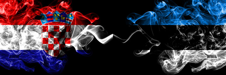 Croatia, Croatian vs Estonia, Estonian smoky mystic flags placed side by side. Thick colored silky abstract smoke flags.