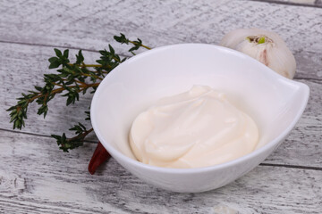 Mayonnaise sauce in the white bowl served thyme and garlic