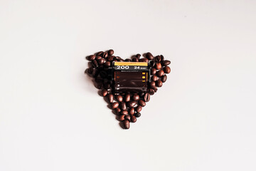 Granos de café formando un corazón junto a un rollo de película analógica de 35mm