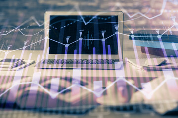 Financial graph colorful drawing and table with computer on background. Double exposure. Concept of international markets.