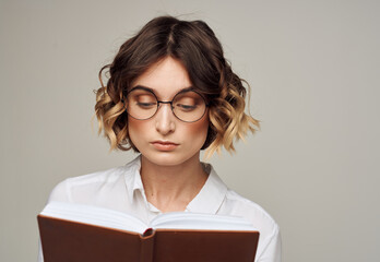 Woman with notepad in hands business finance glasses on her face