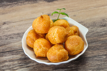 Sweet tasty profiteroles heap in the bowl