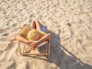 Woman relaxing on beach sitting on sunbed
