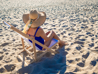 Woman relaxing on beach sitting on sunbed
