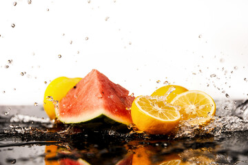 Cool and fresh watermelon and lemons splashing in the water